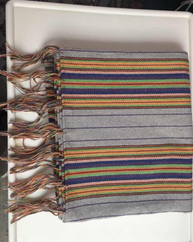 Camino de mesa gris con rayas multicolor y flecos tejido en telar