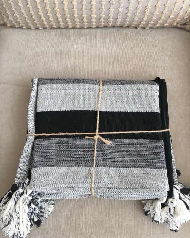 Set de individuales de mesa a rayas grises y negras con borlas, atados con cordel