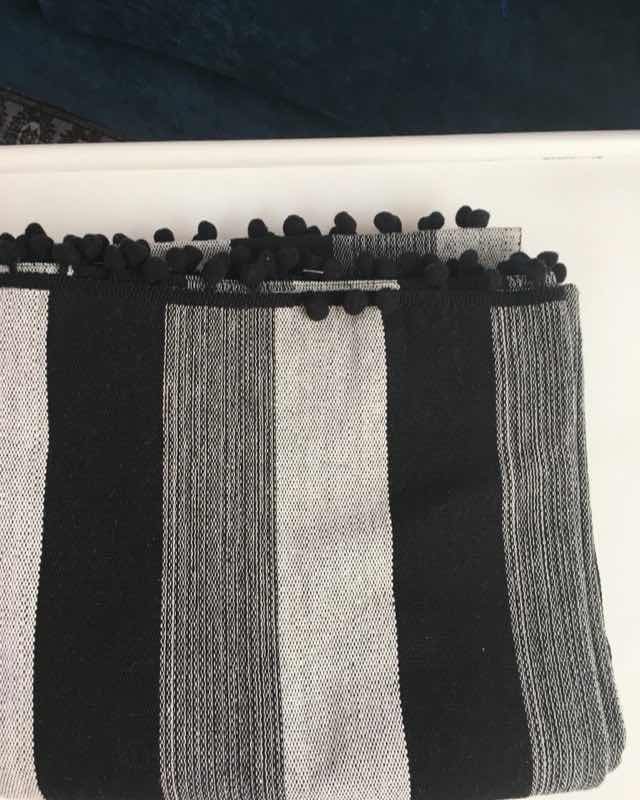 Jerga de lana con anchas franjas negras y grises y pompones negros