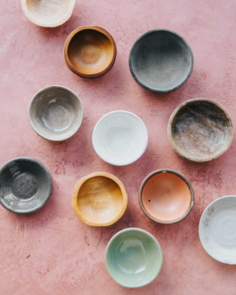 Pozuelos de cerámica artesanal surtidos sobre una mesa de madera